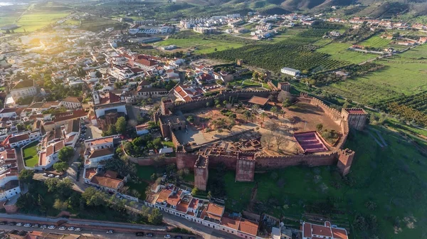 Portugalska zabytkowa wioska Silves, strefa Algarve Alentejo, widok z nieba, antena. Promienie słoneczne w kadrze. Twierdza i kościół na pierwszym planie. — Zdjęcie stockowe