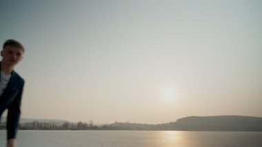 Avrupalı bir adam, kırmızı ceketli, bir rap şarkısı söylüyor. Denizde, sahnenin ortasında..