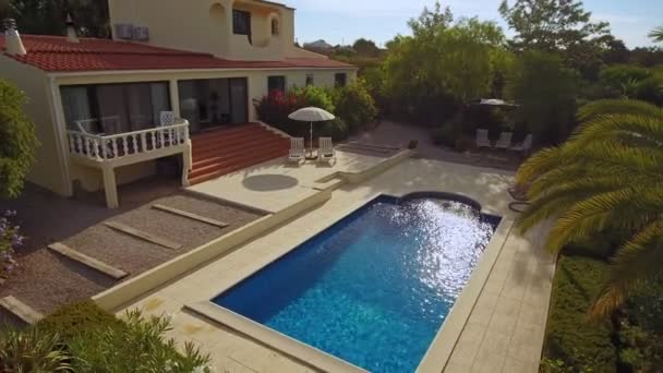 Traditionell europeisk villa med pool, solpanel och välskött trädgård, flygutsikt från himlen. Med tropiska träd, palmer — Stockvideo