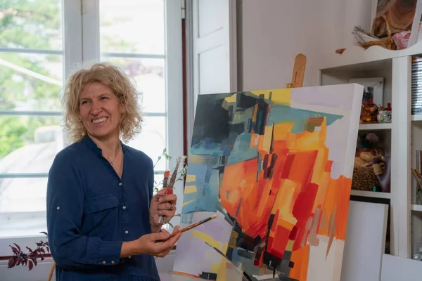 Mujer pintora de dibujos, preparándose para crear una imagen abstracta en el cuadro. En el taller de las galerías.. —  Fotos de Stock