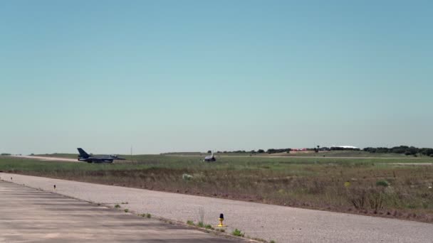 F-16 v dálce, vojenské tryskové letadlo pojíždí, připravuje se ke startu na vzletové dráze letiště. — Stock video