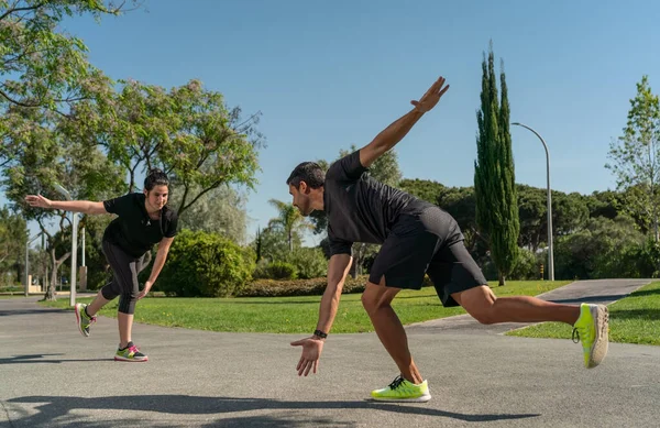 Entrenador de fitness personal para entrenamiento funcional, entrena a un cliente para patinar sobre ruedas. A los parques en el verano. — Foto de Stock