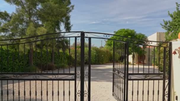 Περνώντας από την πύλη μπροστά με μια βιντεοκάμερα μέσα από το φράχτη ενός ιδιωτικού σπιτιού. Κλειστό ιδιωτικό ακίνητο. — Αρχείο Βίντεο