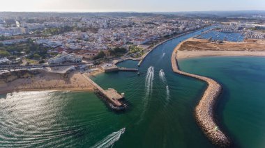 Lagos şehrinin Algarve bölgesinin Portekiz kıyı şeridinden gökyüzü manzarası. Tekneler ve gemiler limana doğru ilerliyor..