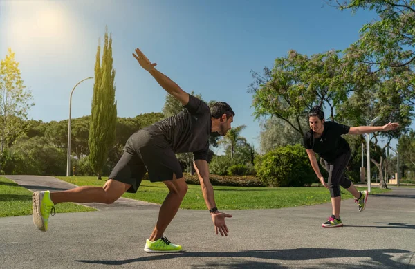 Entrenador de fitness personal para entrenamiento funcional, entrena a un cliente para patinar sobre ruedas. A los parques en el verano. — Foto de Stock