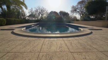 Konutun yanında turistler için temiz suyu olan bahçeli lüks bir yüzme havuzu var. Önde hareket ediyor..