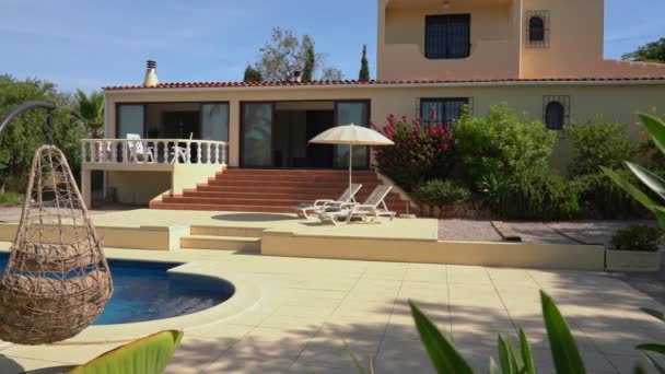 Casa moderna de lujo, villa de vacaciones con piscina y jardín. Con tumbonas y sombrillas en la terraza. — Vídeo de stock