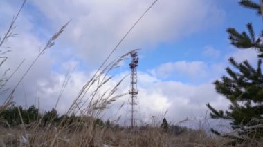 Orman kışı manzarasında televizyon ve radyo yayını için anten. Akıllı telefonlar için 5 G frekansının geliştirilmesi tartışması.
