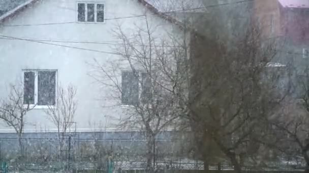 Zimní dramatický pohled na sníh, s domem v pozadí. Zpomalený pohyb. — Stock video
