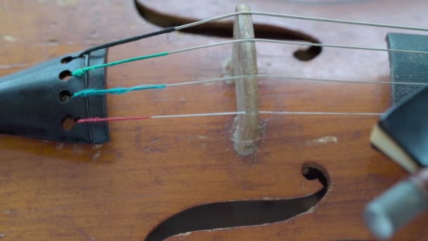 Violino clássico retrô antigo, primeiro tamanho, em uma mesa de madeira. Humor musical dramático. Vá da esquerda para a direita. Arco em cordas. — Vídeo de Stock