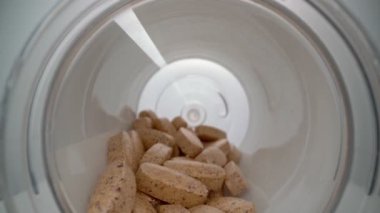 Ekstrem makro video vitamin ve minerallerle dolu bir şişeye doğru ilerliyor. Sporcular ve hastalar için.