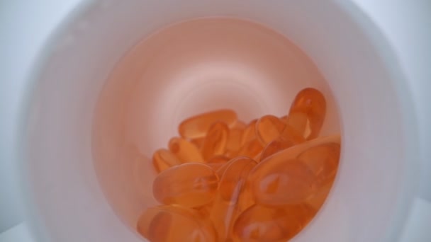 Vidéo macro extrême se déplaçant vers l'avant dans une bouteille avec des capsules avec des acides gras oméga. Pour athlètes et patients. — Video