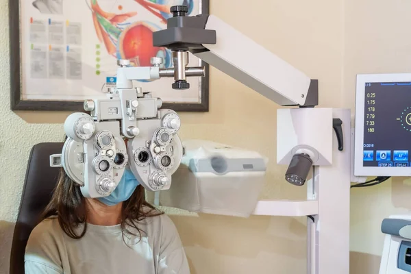 Junges Mädchen mit Maske beim Augenarzttermin. Sehtest. In der Augenklinik. — Stockfoto