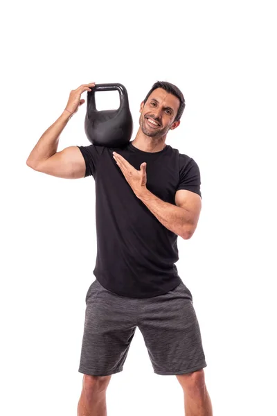 Athlete is a European man, holding a weight on shoulder, pointing with finger, advertising a healthy sports lifestyle. On a white background. — Stock Photo, Image