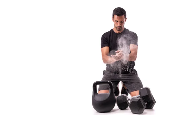 European athlete preparing for training, clapping his hands, with chalk, raising a cloud. On a white isolated background. Copy space. — Stock Photo, Image