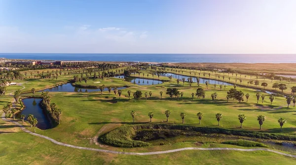 Zelená golfová hřiště u moře. Pláž Salgados. Portugalsko, Albufeira. Letecký výhled a vysoké stromy, slunečný den — Stock fotografie