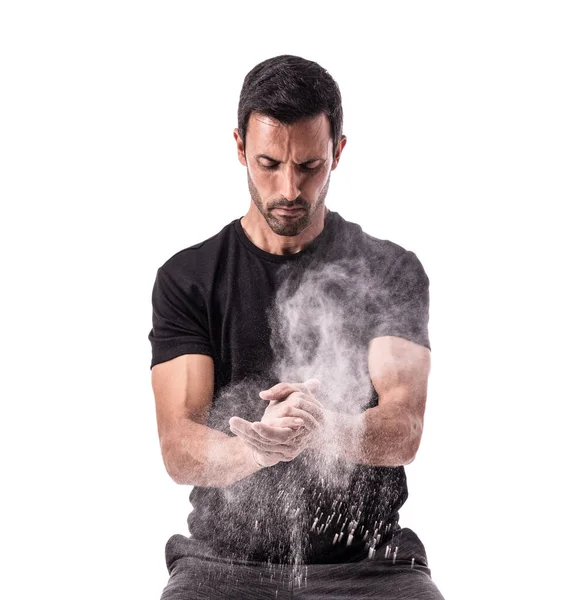 European athlete preparing for training, clapping his hands, with chalk, raising a cloud. On a white isolated background. — Stock Photo, Image