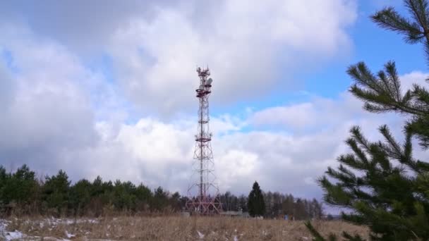 Antena do nadawania programów telewizyjnych i radiowych, w leśnym zimowym krajobrazie. Kontrowersje dotyczące rozwoju częstotliwości 5 g dla smartfonów. — Wideo stockowe