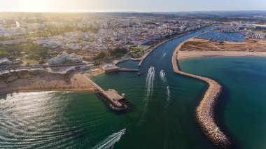 Lagos şehrinin Algarve bölgesinin Portekiz kıyı şeridinden gökyüzü manzarası. Tekneler ve gemiler limana doğru ilerliyor..
