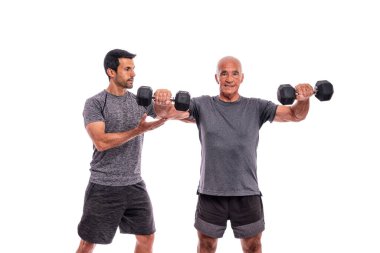  Kişisel antrenörü olan yaşlı bir adam fitness antrenmanı yapıyor. İzole edilmiş beyaz bir arka planda. Beyaz arkaplan.