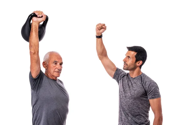 Old man with a personal trainer is conducting a fitness workout. Dumbbell lesson. White background. — Stock Photo, Image