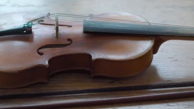Antique retro classical violin, first size, on a wooden table. Musical dramatic mood. Move from left to right.