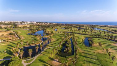 Deniz kenarındaki yeşil golf sahaları. Salgados plajı. Portekiz, Albufeira. Hava görünümü.