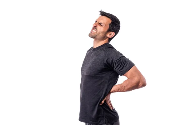 Atletisk medelålders man med smärta i ryggraden. Ryggradsbehandling. På en isolerad vit bakgrund. Kopiera utrymme. — Stockfoto