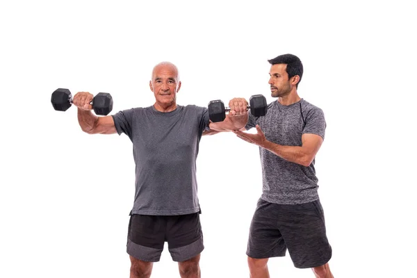 Gamle mannen med en personlig tränare genomför en fitness träning för att upprätthålla hälsan. På en isolerad vit bakgrund. Vit bakgrund. — Stockfoto