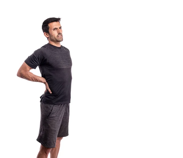 Sportlicher Mann mittleren Alters mit Schmerzen in der Wirbelsäule. Auf einem isolierten weißen Hintergrund. Kopierraum. — Stockfoto