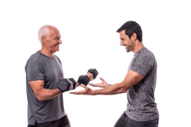  Kişisel antrenörü olan yaşlı bir adam fitness antrenmanı yapıyor. Ahmak dersi. Beyaz arkaplan.