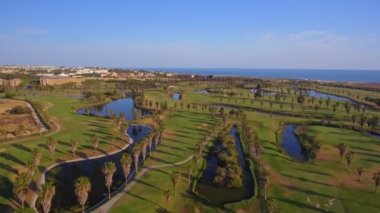 Deniz kenarındaki yeşil golf sahaları. Salgados plajı. Portekiz, Albufeira. Hava görünümü.