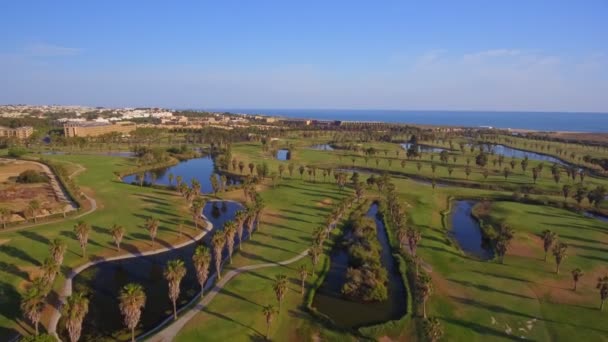 Зеленые поля для гольфа у моря. Пляж Сальгадос. Португалия, Албуфейра. Вид с воздуха. — стоковое видео