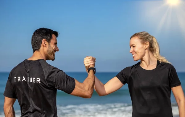 Fitness trenérka a klientka, evropská žena, si potřásají rukou. Na pozadí moře v létě. Slunečný den — Stock fotografie