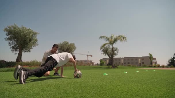 Un formateur d'âge moyen en formation dans le parc avec un jeune homme. Poussez-vous. Courir avec le ballon. Faro Portugal 2021 16 avril — Video