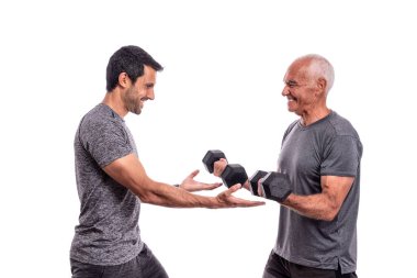  Kişisel antrenörü olan yaşlı bir adam fitness antrenmanı yapıyor. Sağlık ve spor. İzole edilmiş beyaz bir arka planda. Beyaz arkaplan.