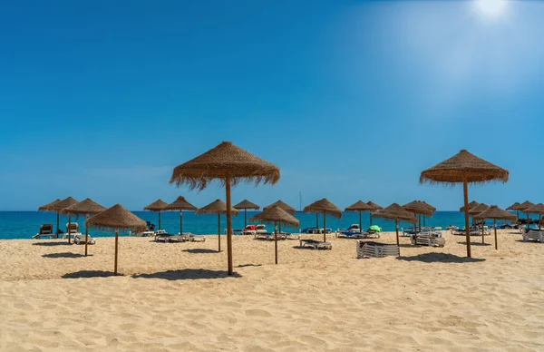 Uitzicht op het luxe strand aan zee met ligstoelen en parasols, in de toeristische zone van de tropen. Zonnige dag — Stockfoto