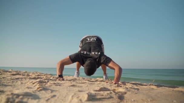 Un surfista simula levantar el cuerpo en una tabla, en la playa, con un instructor para enseñar habilidades de surf. Un principiante en una escuela de surf. Portugal Faro 2021 15 de marzo — Vídeos de Stock