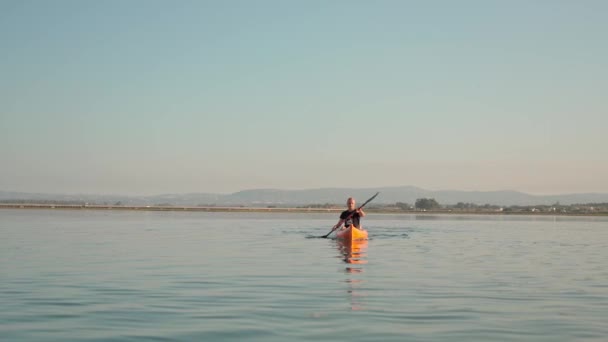 Ein Sportler in einem Kajak-Kanu-Boot, das auf dem Fluss Ria Formosa paddelt. Er trainiert für Wettkämpfe. Portugal Faro 2021 15. März — Stockvideo