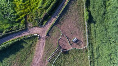 Parkın tepesinden havadan çekilmiş bir fotoğraf. Ağaçları ve otlakları olan bir vadi. Orman yollarından geçiyorum. Resimli manzara..