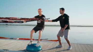 Dengeleme topundaki bir rüzgar sörfçüsü lastik genişleticilerle sörf tahtasını uyarır. Denge ve dengeyi geliştirmek için. Portekiz Faro 2021 Mart 15 