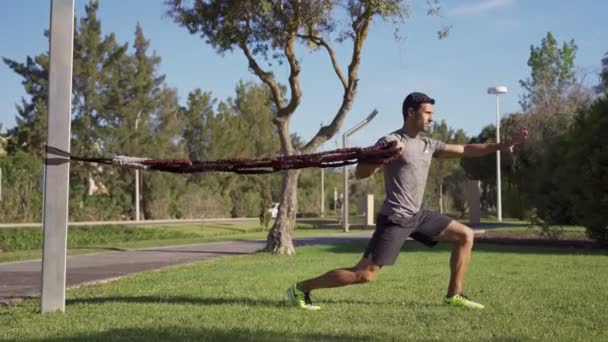 Homem de meia-idade atleta no parque em treinamento. Comboios lunge isométrico.. Lunge com o pé para a frente .Blue Sky. Faro Portugal 2021 16 de Abril — Vídeo de Stock