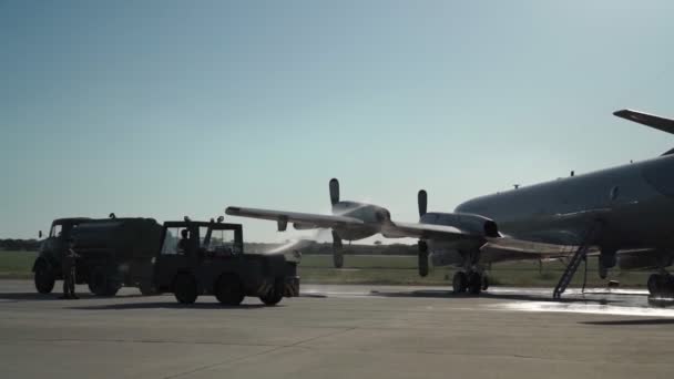 Американский военный самолет, с аварийной посадкой после аварии и перегревом двигателей. Помощник поливает водой подогреваемые двигатели. — стоковое видео