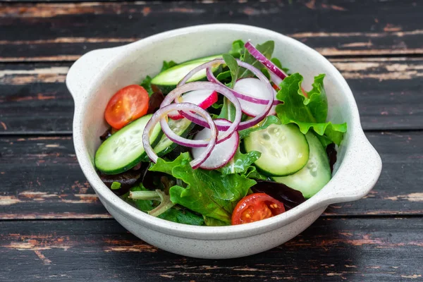 Salada vegana de verduras de uma dieta, em uma chapa, em um contexto de safra de madeira. Close-up. — Fotografia de Stock