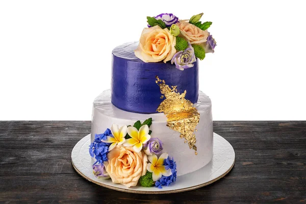 Um belo bolo de casamento conceitual feito de dois andares, flores de rosa e jóias de ouro. Em uma mesa de madeira, em um fundo branco. — Fotografia de Stock