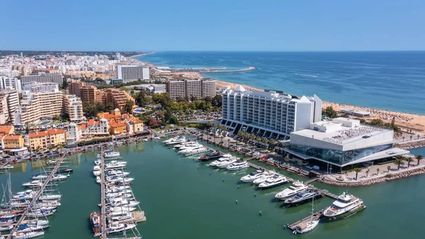 Ein Blick vom Himmel auf die portugiesische Touristenstadt Vilamoura, mit Yachten und Segelbooten, die im Hafen auf dem Dock festgemacht haben. — Stockfoto