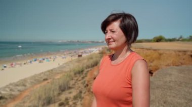 Orta yaşlı kadınlar, kardiyo eğitimi için saate bakıyorlar. Kumsal manzaralı deniz kıyısında..