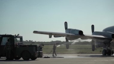 Kazadan sonra acil iniş yapan ve motorları aşırı ısınan bir Amerikan askeri uçağı. Asistan ısıtılmış motorların üzerine su döker..