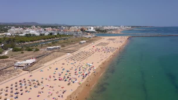 Flygvideo, vackra portugisiska stränder, nära turiststaden Vilamoura, Falesia, med utsikt över hamnen. Turister solbadar. — Stockvideo