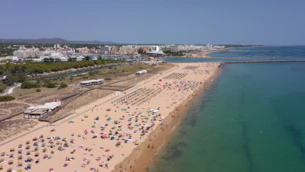 Wideo lotnicze, piękne portugalskie plaże, w pobliżu miejscowości turystycznej, Vilamoura, Falesia, z widokiem na dok. Turyści opalają się. — Wideo stockowe